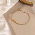 May include: A gold-colored bracelet with the name "Chris" in cursive script. The bracelet is made of a delicate chain and has an adjustable length. The clasp is visible at the end of the chain. The bracelet is displayed on a neutral-toned surface.